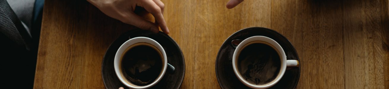 Dos personas tomando café y hablando