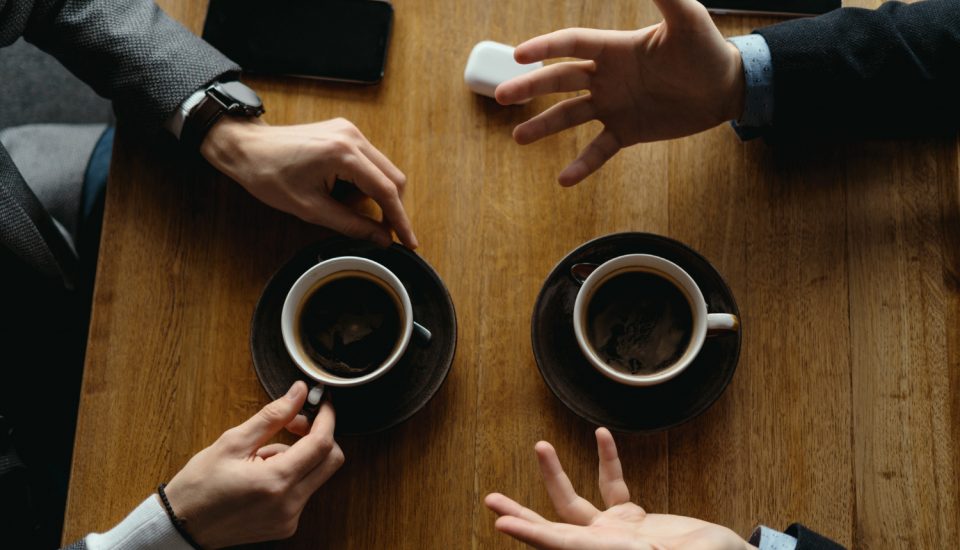 Dos personas tomando café y hablando