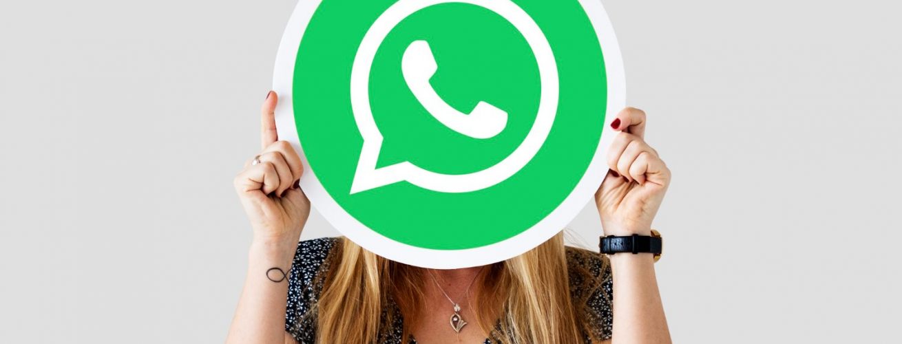mujer mostrando el icono de whatsapp sobre su cara