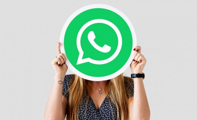 mujer mostrando el icono de whatsapp sobre su cara