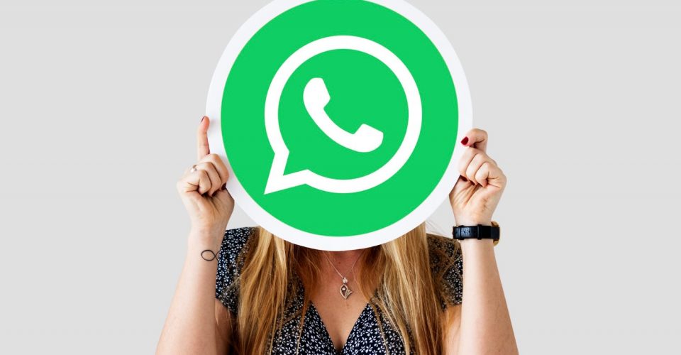 mujer mostrando el icono de whatsapp sobre su cara
