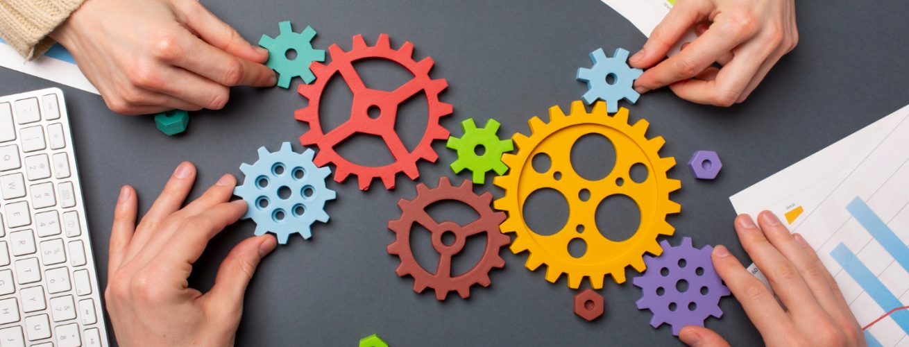 engranajes en una mesa con manos