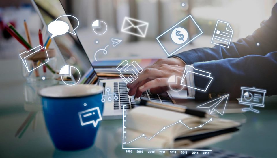 ordenador con elementos digitales flotando alrededor