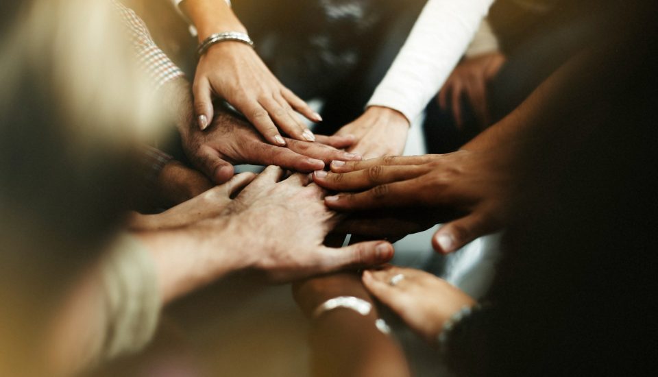 primer-plano-diversas-personas-uniendo-sus-manos